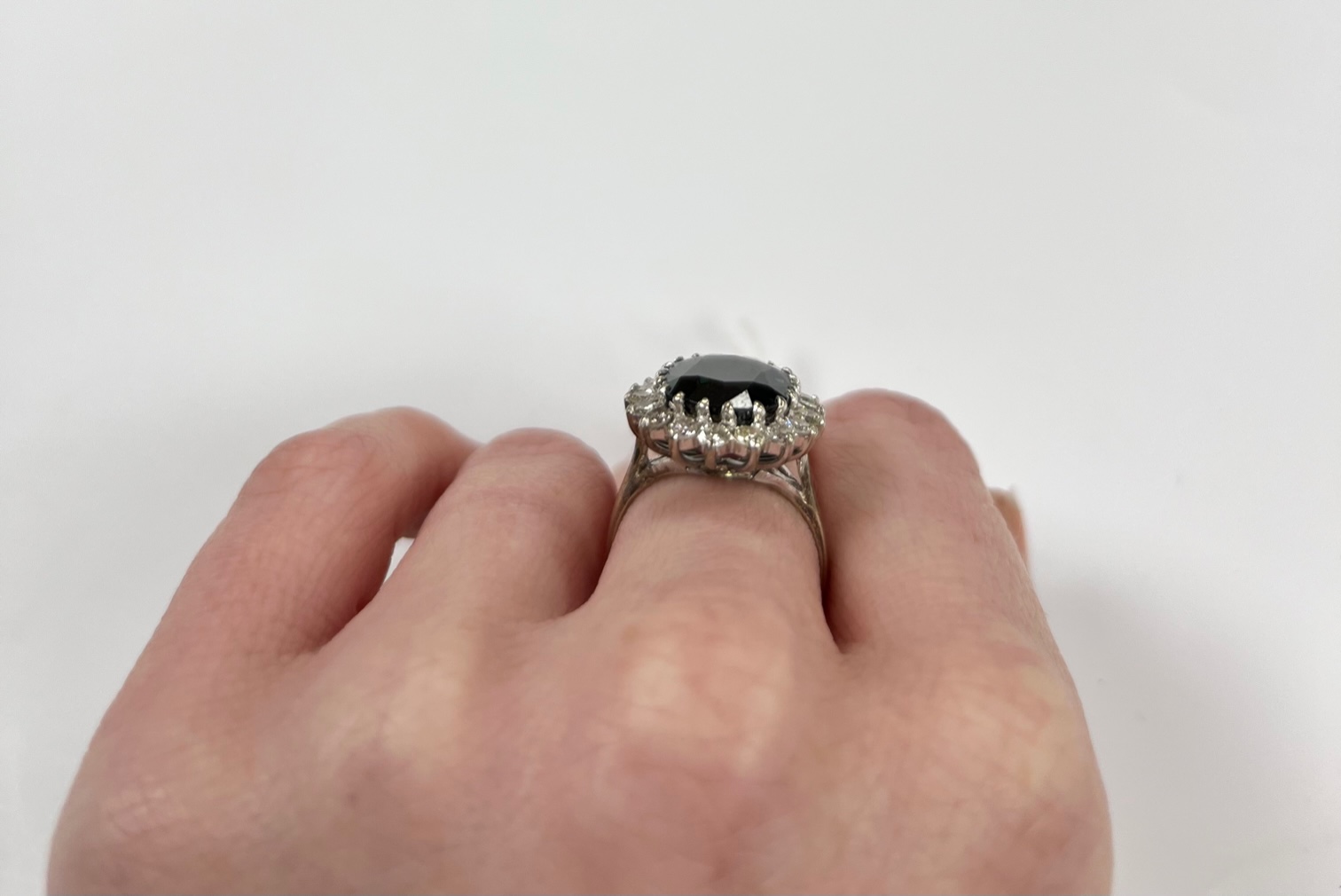 An 18ct, sapphire and diamond set oval cluster ring, size L, gross weight 5.7 grams.